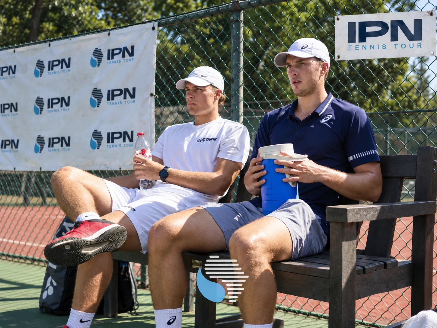 Two IPN Tennis Tour players seated courtside